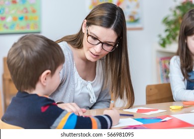 Kindergarten Teacher Supports Child On Class