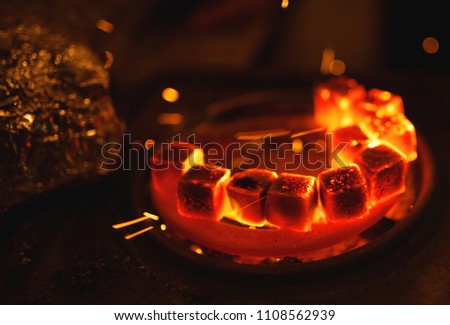 Kindling of square coal for a hookah on a special furnace with a hot spiral