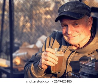 Kindly Old Man Holding Glass Of Beer In His Hand. He Is Smiling.