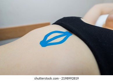 Kinesio taping, kinesiology. Girl with kinesio tape, muscle tape on her stomach.