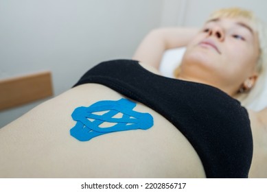 Kinesio taping, kinesiology. Girl with kinesio tape, muscle tape on her stomach.