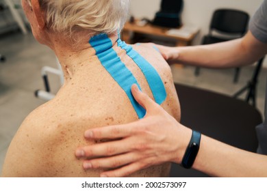 Kinesiology Therapeutic Tape Treating Wrinkled Back Skin Of Pensioner