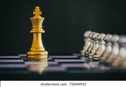 The King in battle chess game stand on chessboard with black isolated background. Business leader concept for market target strategy. Intelligence challenge and business competition success play.