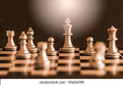 The King in battle chess game stand on chessboard with black isolated background. Business leader concept for market target strategy. Intelligence challenge and business competition success play.