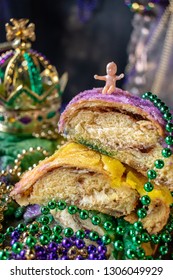 king cake with baby surrounded by mardi gras beads