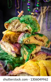 king cake with baby surrounded by mardi gras beads