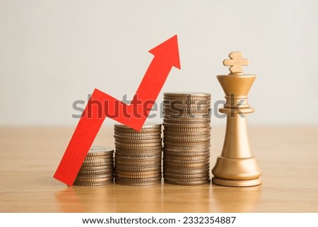 King chess and stacked coins as growth profit up graph with red arrow chart on wooden table with white wall background. Business strategy, gain investment trading, planning for achieve successful.