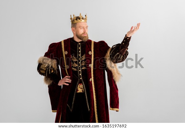king with\
crown pointing with hand isolated on\
grey