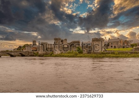 King John castle in Limerick Ireland on the banks of the Shannon river with dramatic cloudy sunset sky