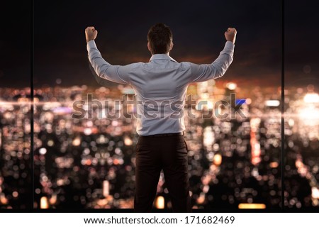 King of the world, young successful businessman in front of the city at night