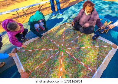 Kings Creek Station, Northern Territory, Australia - Aug 21, 2019: Australian Aboriginal Woman Shows The Traditional Bush Painting Art. Karrke Aboriginal Cultural Experience Tour In Australian Outback