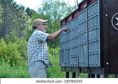 Kingston, New Brunswick / Canada - May 29 2018:  Senior Man Getting Mail From Community Mailbox