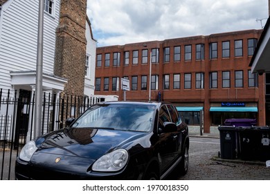 Kingston Upon Thames London UK, May 07 2021, Black Porsche Cayenne Parked In A Driveway With No People With Offices In The Background And No People