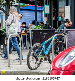 Kingston-Upon-Thames, London, UK, August 29 2022, People Walking Past A Restaurant Outside Seating Area With Parked Bicycles On Pavement