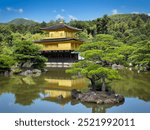 Kinkaku-ji, the Golden Pavilion in Kyoto, Japan, reflects on a serene pond surrounded by lush gardens. A stunning example of Zen architecture and harmony with nature.