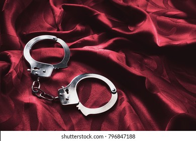 Kinky Handcuffs On A Red Bed Sheet