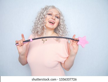 Kinky Pretty Woman With Pink Star Riding Crop. Cute Blonde Woman Holds Bdsm Whip On White Solid Studio Background.