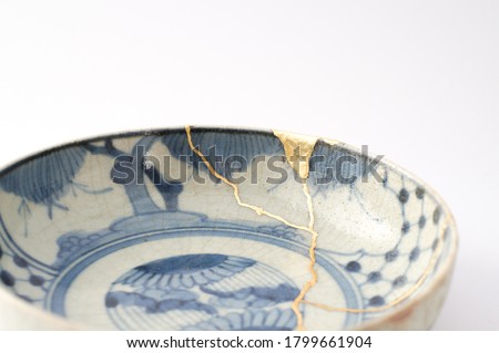 Kintsugi antique japanese plate. Gold cracks restoration on old Japanese pottery restored with the antique restoration technique.The unique beauty of imperfections. 