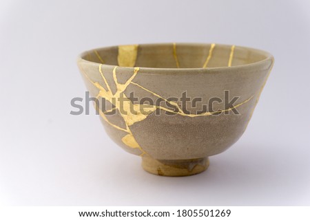 Kintsugi beige tea ceremony chawan. Gold cracks restoration on old Japanese pottery restored with the antique Kintsugi restoration technique. The beauty of imperfections. 