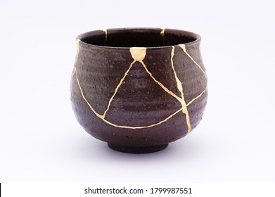 Kintsugi bowl. Gold cracks restoration on old Japanese pottery restored with the antique restoration technique.The unique beauty of imperfections. 