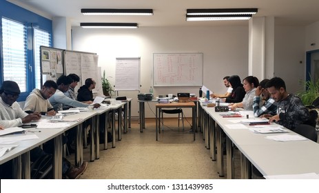 Kirchheimbolanden / Germany - February 12 2019: Groups of adult students of different nationalities and ages,learning german language by immersion in the classroom,writing in notebooks,selective focus - Shutterstock ID 1311439985