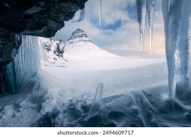 Kirkjufell mountain during winter at sunrise, shot behind the frozen waterfall, icicles in the foreground, original view, beautiful day, landscape nature - Powered by Shutterstock