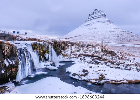 Kirkjufellsfoss Waterfall and  Kirkjufell Mountain in winter in Iceland
