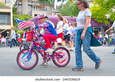 Kirkland WA July 4, 2019. A Girl Is Riding Her Bike At The 4th Of July Parade.