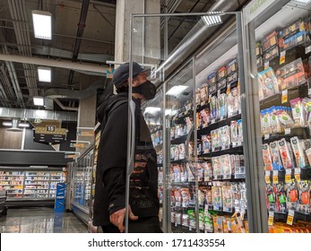 Kirkland, WA / USA - Circa April 2020: Man Wearing A Face Mask And Shopping In The Deli Meat And Cheese Aisle During The COVID-19 Pandemic.