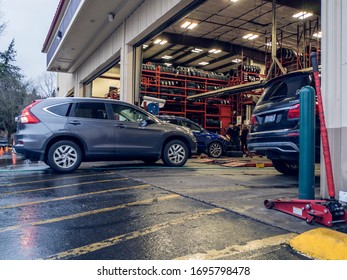 Kirkland, WA / USA - Circa January 2020: View Of A Discount Tire Shop Garage And Mechanics Hard At Work Maintaining Cars.