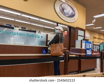 Kirkland, WA USA - Circa October 2021: View Of A Woman In A Baseball Hat Picking Up A Prescription At A Pharmacy Inside A Safeway Grocery Store