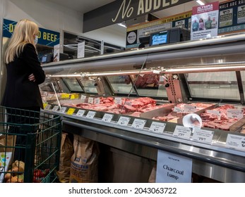 Kirkland WA USA - circa September 2021: View of a blonde woman waiting at the meat counter inside a Whole Foods Market grocery store.