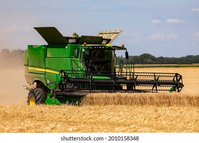 Kiskunhalas Hungary  July. 17 2021: Modern John Deere Combine Harvesting Grain In The Field Near The Town.