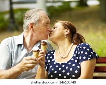 Kiss Happy Old Couple Eating Ice-cream Outdoor.