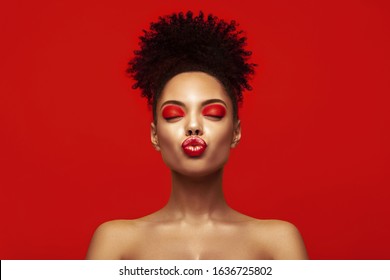 Kiss lips. Share love.Valentine Day. African makeup face. Satisfied Brunette young woman with afro hair style against colorful background. 