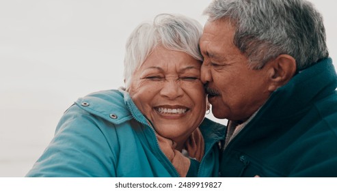 Kiss, love and elderly couple on beach together for holiday bonding, retirement or vacation. Anniversary, romance or smile with senior man and woman on tropical island coast for peace or travel - Powered by Shutterstock