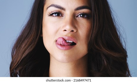 Kissable, Likable, Luscious Lips. Studio Shot Of An Attractive Young Woman Licking Her Lips Against A Gray Background.