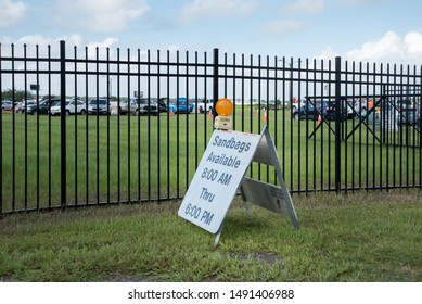 Kissimmee, Florida /USA -August 29, 2019: Cars Waiting In Line By Sandbags Available Signs In Osceola County FL Heritage Park In Prep For Hurricane Tropical Storm Dorian