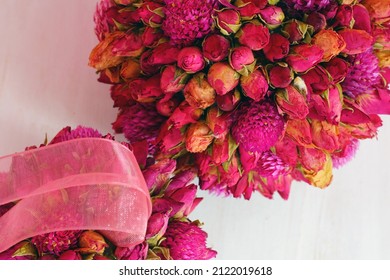 Kissing ball pomander ornament with pink dried roses and gomphrena flowers