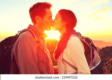 Kissing couple romantic at sunset. Romance kiss in nature. Young woman and man.