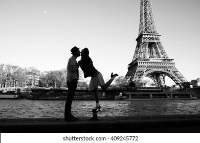 Kissing couple silhouettes under the Eiffel Tower in black and white