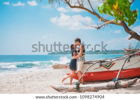 Kissing loving man and woman on vacation on a trip to a beautiful tropical beach. Palm trees, sun and sand. Tropical island beach and ocean.