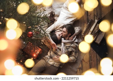 Kissing stylish love couple girl, guy lie on skin on floor in cozy wooden country house,chalet in winter forest.Celebrating new year eve.Gifts,family holiday.Romantic weekend.Decorated Christmas tree. - Powered by Shutterstock