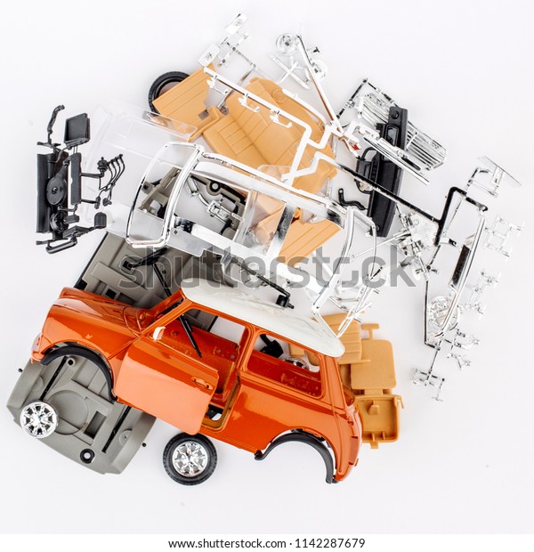 kit for assembling gray plastic car model on\
white background