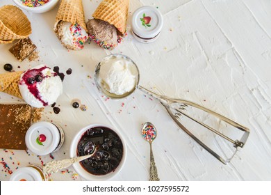 A Kit For Making Ice Cream: Spoon For Ice Cream, Ice Cream Cones, Jam, Topping, Chocolate, Sprinkles, Coconut Shavings. on white background. Concept Ideas For A Gift With Their Own Hands.