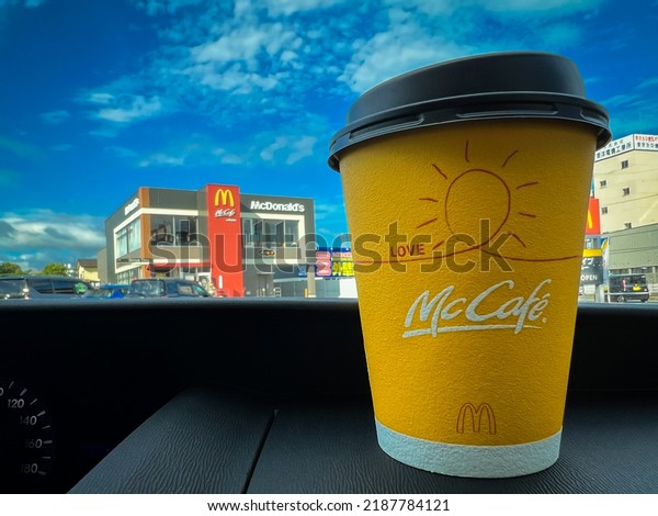 Kitakyushu, Fukuoka, Japan \ August 6, 2022:\
Yellow cup of McCafe coffee on the dashboard of a car bought at\
McDonald\'s drive thru\
service.