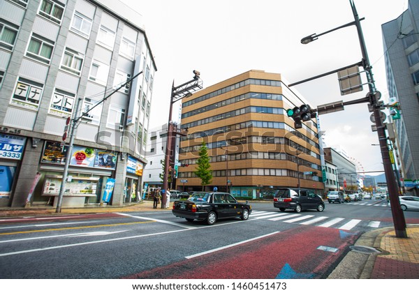 Kitakyushu, Japan - November 22, 2016 : Cars in\
Kitakyushu, Fukuoka Prefecture, Japan, City Road, with a few cars\
and small number of pedestrians In the morning the rain is going to\
fall in the fall.