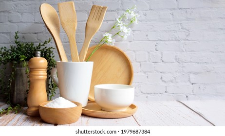 Kitchen accessories in white wooden table and white background and white tableware with salt in wooden bowl and tree. Kitchen minimal cooking time in holiday concept.
