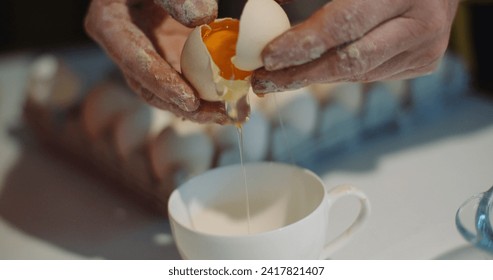 Kitchen Activities - woman breaking egg into bowl in kitchen. Woman Preparing food in kitchen breaking eggs and bake a cake. - Powered by Shutterstock