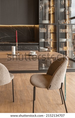 kitchen area in a chic expensive interior of a luxury home with a dark black and brown modern design with wood trim and led light